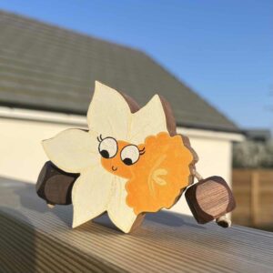 Little daffodil made out of walnut, painted in white with an orange centre and face
