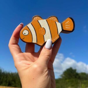 Clown fish in walnut being held in a hand