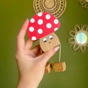 Mushroom made from oak with a red top with white spots. A smiley face with legs