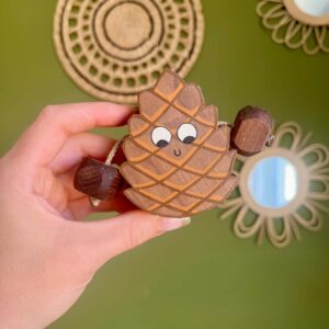 Pinecone in walnut with a smiley face and arms