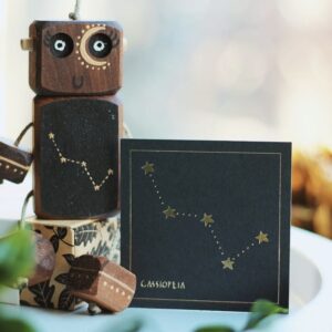 Hand-painted Cassiopeia Ned wooden robot in walnut with matching constellation gift card by Rudi & Bear.