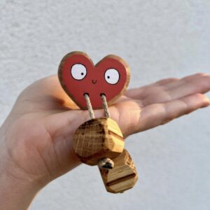 Handmade rainbow wooden heart toy in red held in hand, open ended wooden toy, eco friendly UK