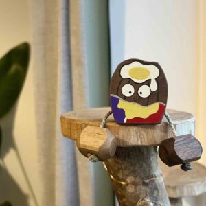 Hand painted wooden creme egg character with dangling legs by Rudi and Bear